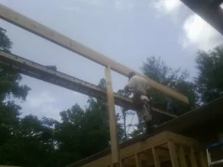 Carpenter setting a ridge beam over a new addition frame — Ice Dam Removal by Roofing Brothers in Sheboygan Falls