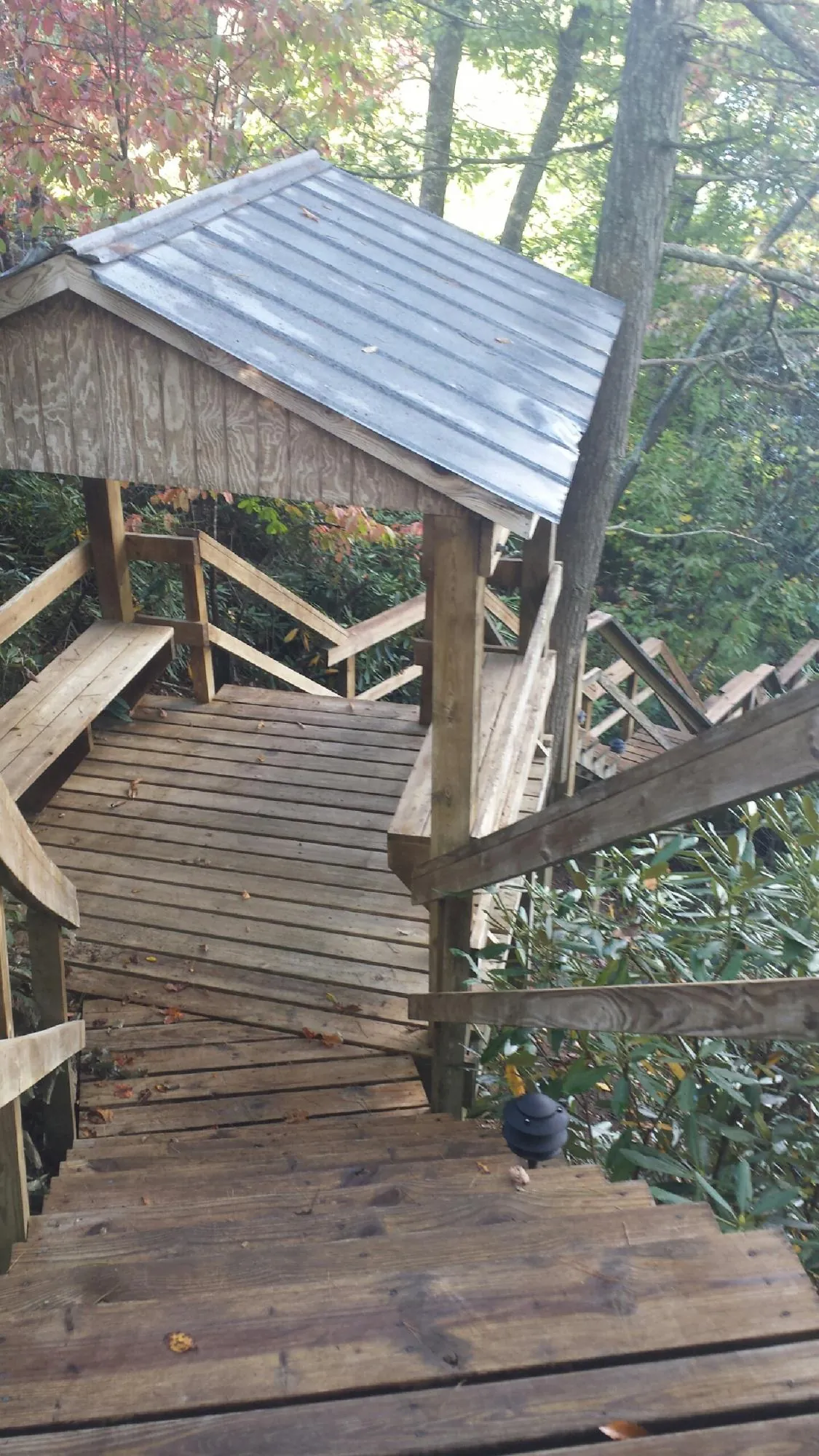 Metal roofed shelter over wooden steps on a wooded walkway — Skylight Repair & Installation work by our crew in Sheboygan Falls
