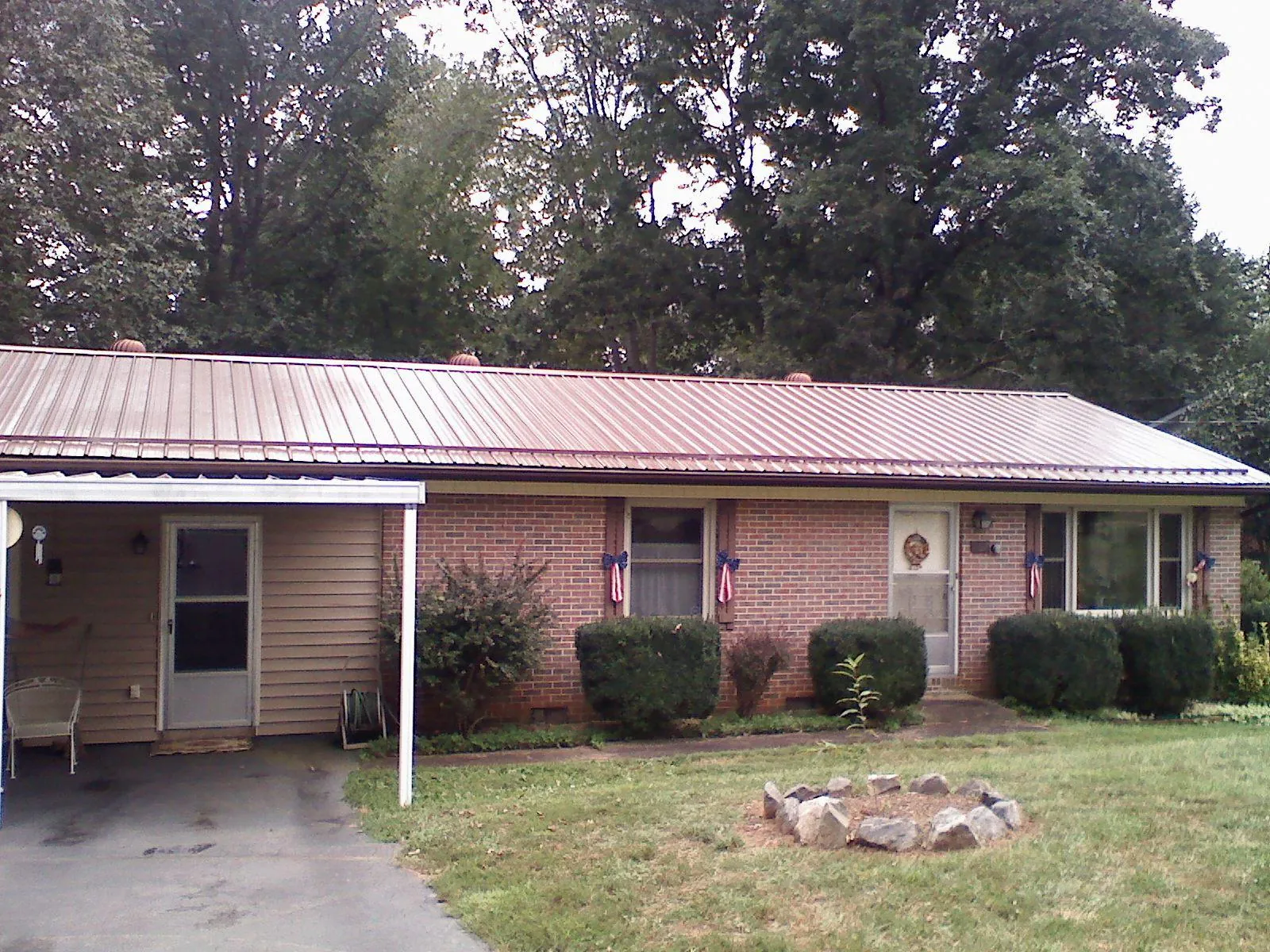 Bronze metal roof and carport on a brick ranch home — Roof Repair work by our crew in Sheboygan Falls