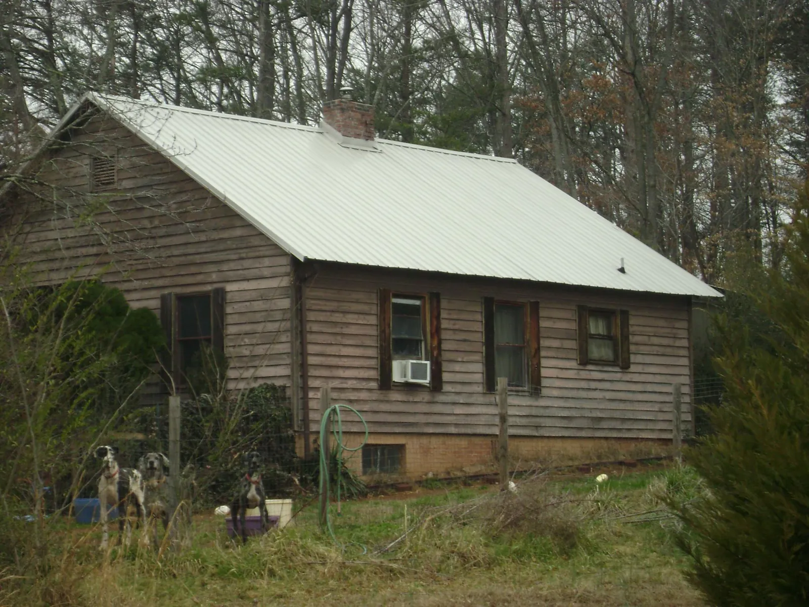 White metal roof on an old wood sided farmhouse, from a Metal Roof Installation job in Sheboygan Falls